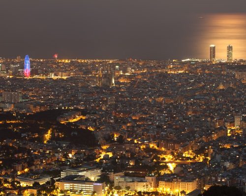 BARCELONA, SPAIN - JULY 12: Barcelona skyline at night with Agbar tower and Sagrada Familia standing out in the left on July 12, 2014 in Barcelona.